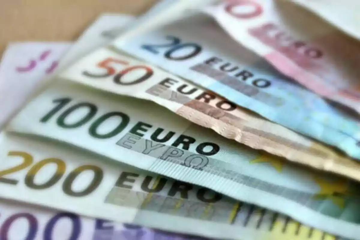 Billetes de euro de diferentes denominaciones apilados en forma de abanico.