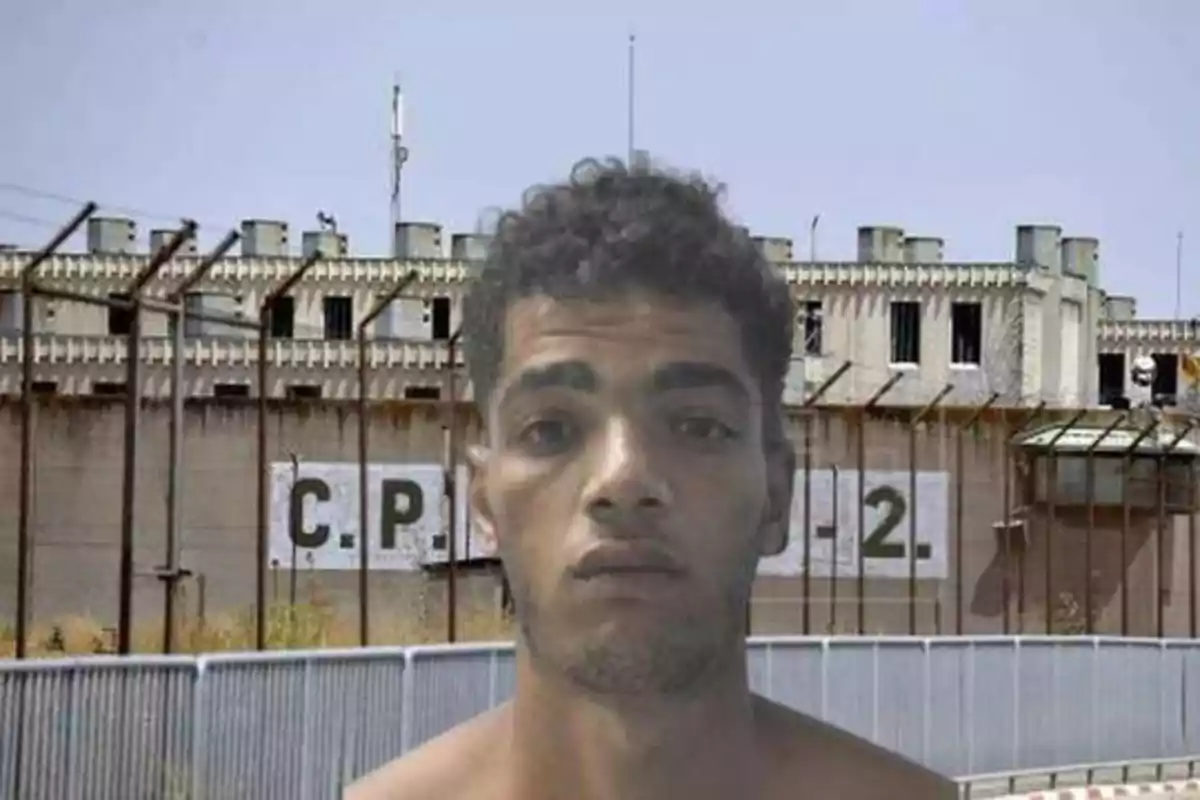 Hombre frente a una prisión con la inscripción "C.P. 2" en la pared.