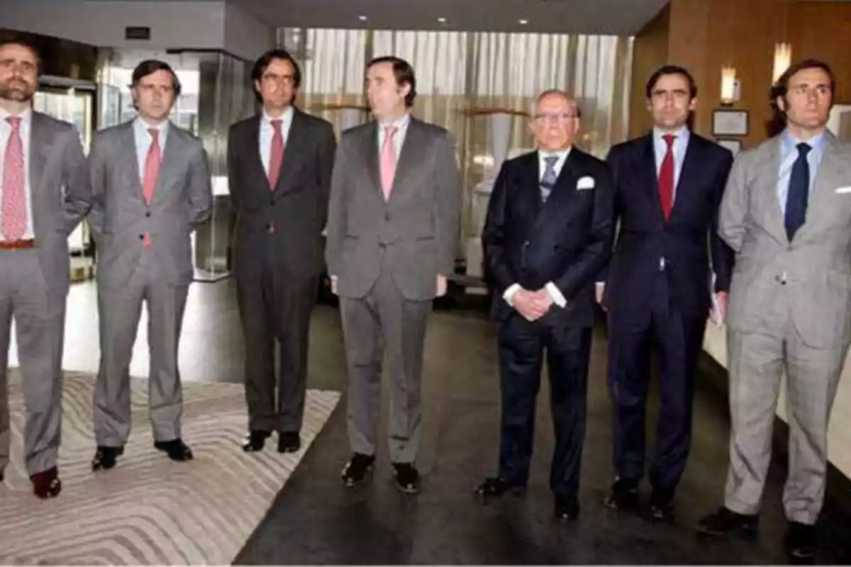 Un grupo de hombres en trajes formales posando en un entorno de oficina.