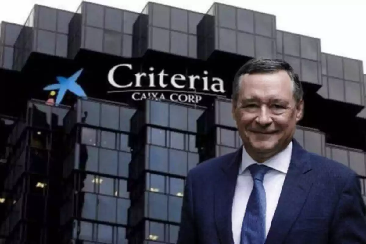 Un hombre con traje y corbata azul está de pie frente a un edificio de oficinas con el logotipo de Criteria Caixa Corp.