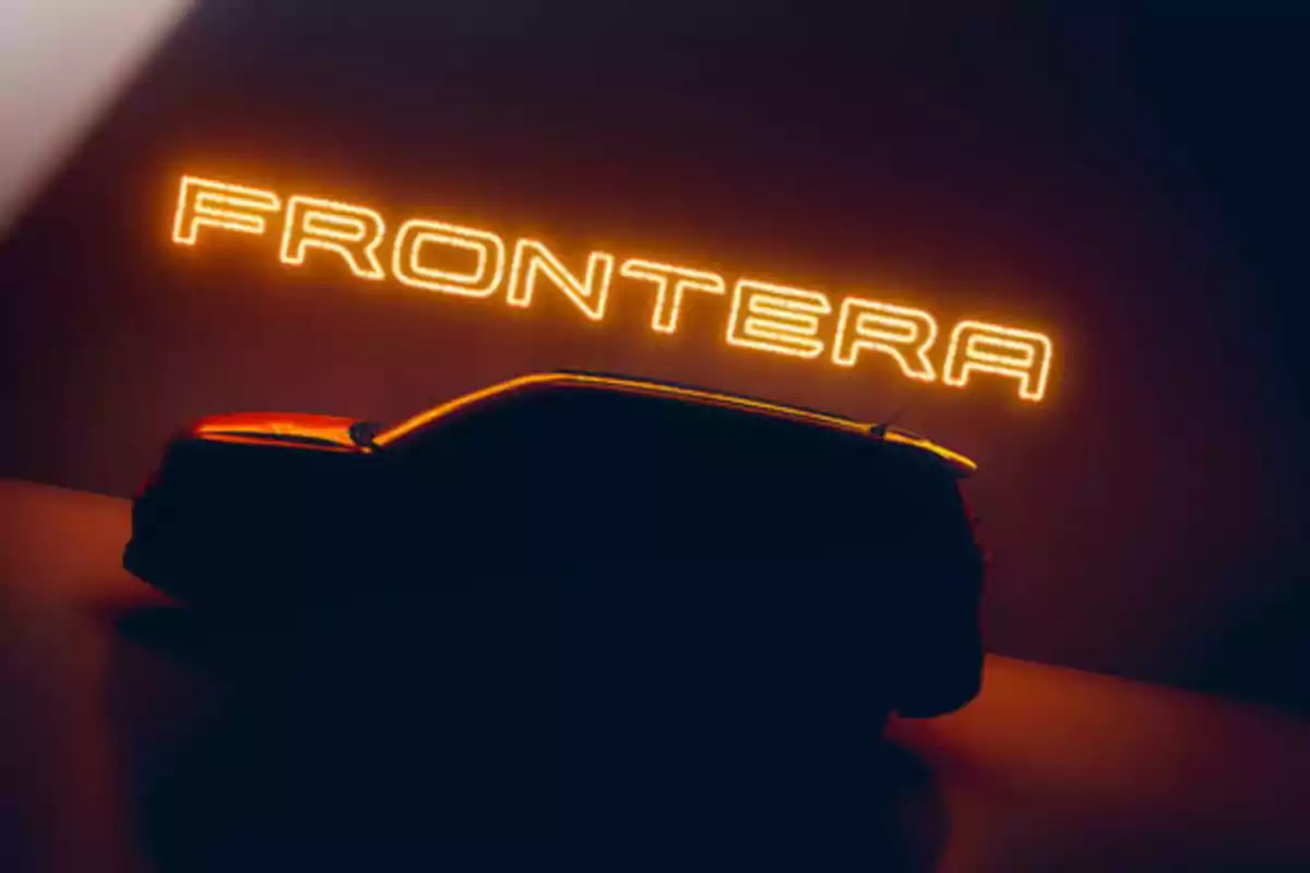 Silueta de un automóvil con la palabra "FRONTERA" iluminada en neón naranja en el fondo.