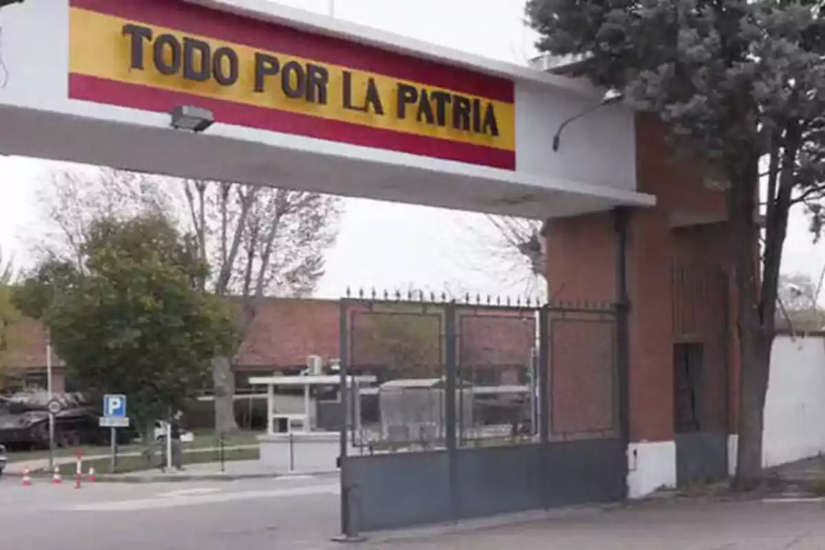 Entrada de una instalación militar con un letrero que dice "TODO POR LA PATRIA" en la parte superior.