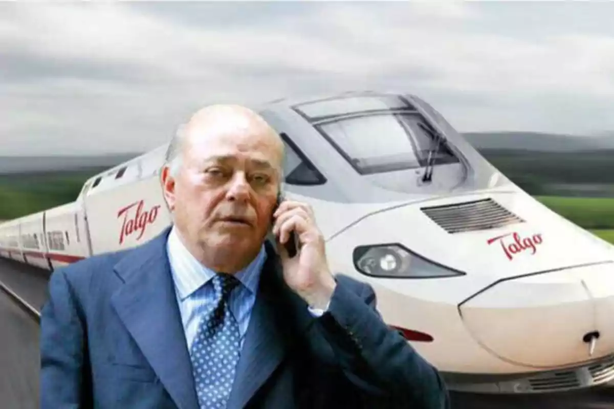 Hombre de traje hablando por teléfono frente a un tren de alta velocidad de la marca Talgo.