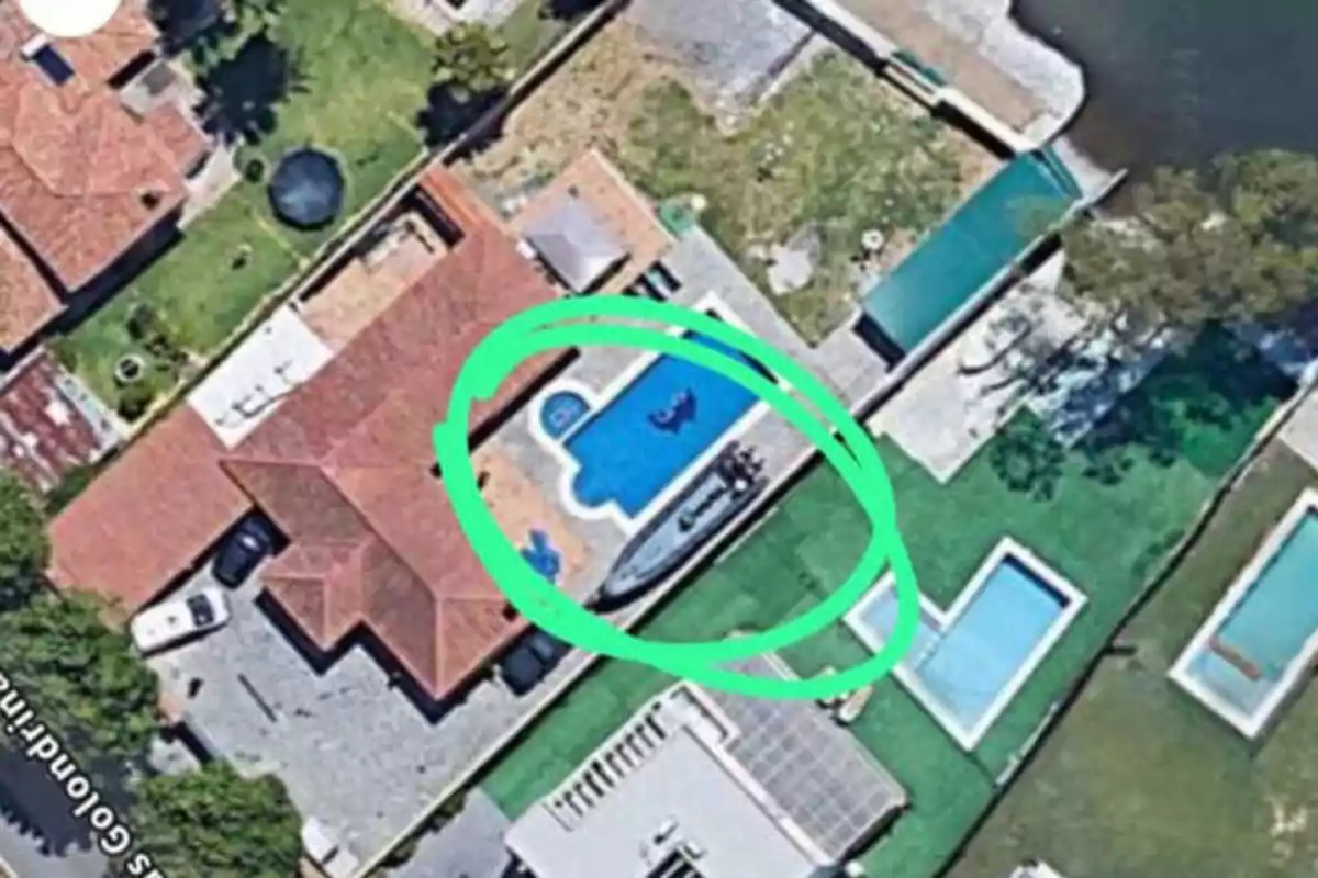 Vista aérea de una casa con piscina, rodeada por un círculo verde.