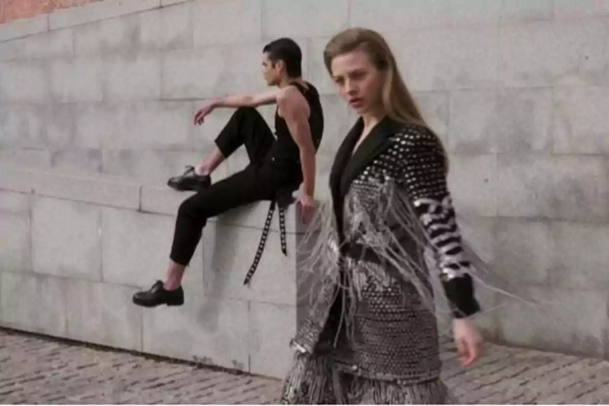 Dos personas posando con ropa de moda en un entorno urbano.