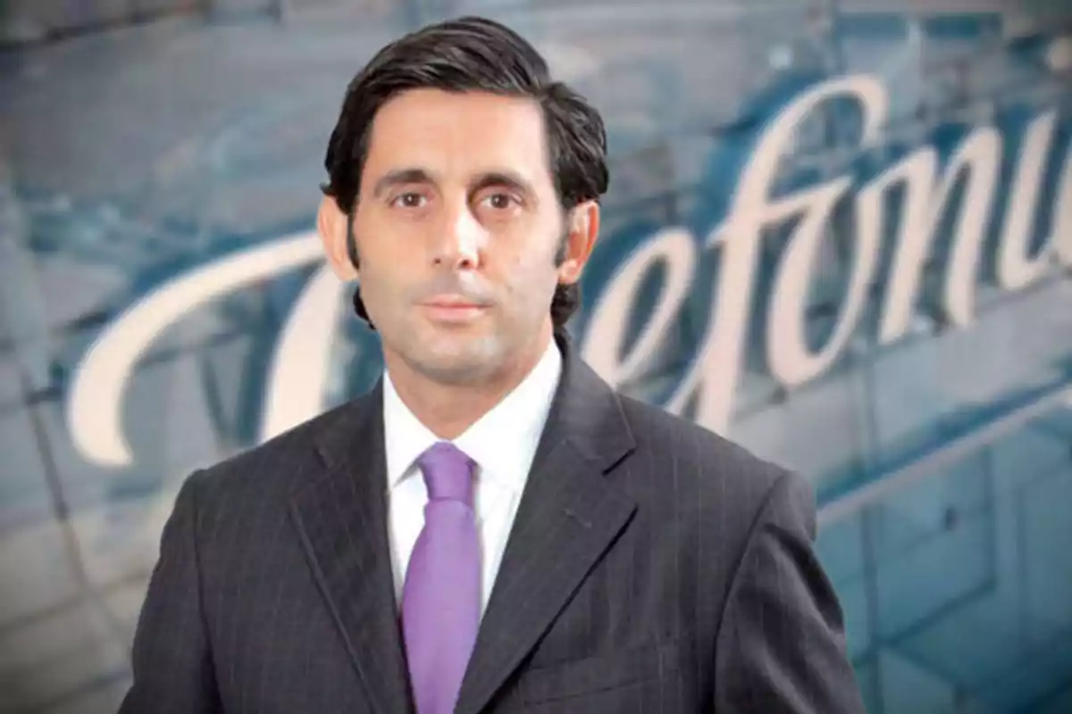 Hombre con traje y corbata morada frente a un fondo con el logo de Telefónica.