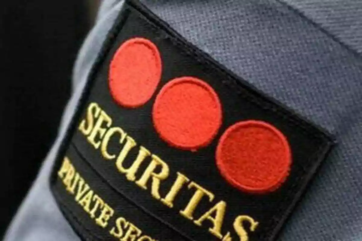 Insignia de seguridad privada con tres círculos rojos y el texto 
