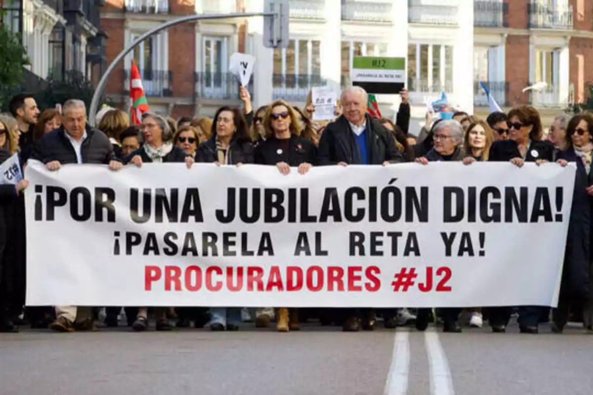 Personas marchando en una manifestación con una pancarta que dice "¡Por una jubilación digna! ¡Pasarela al RETA ya! Procuradores #J2".
