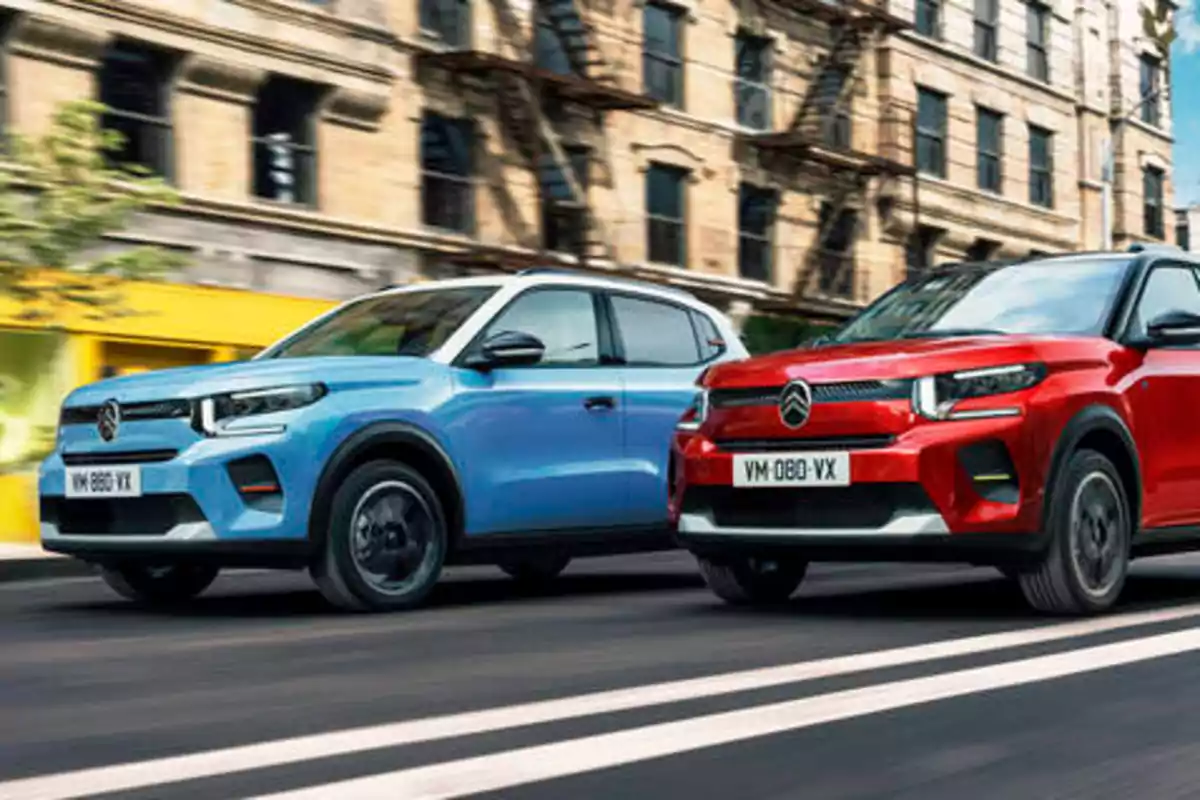 Dos autos Citroën, uno azul y otro rojo, circulando por una calle urbana.