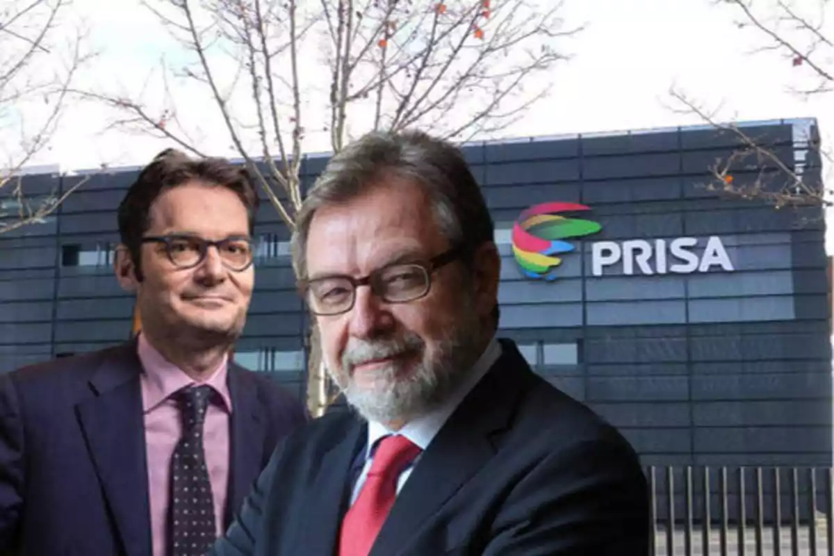 Dos hombres con trajes formales posan frente a un edificio con el logotipo de PRISA.