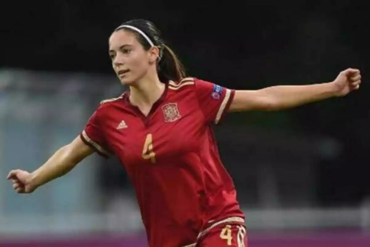 Jugadora de fútbol con uniforme rojo de la selección española en acción durante un partido.