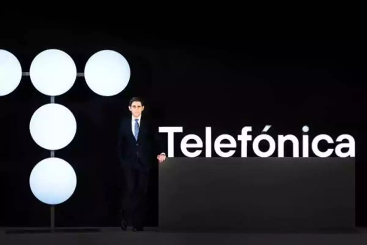 Hombre de traje junto al logo de Telefónica en un fondo negro.
