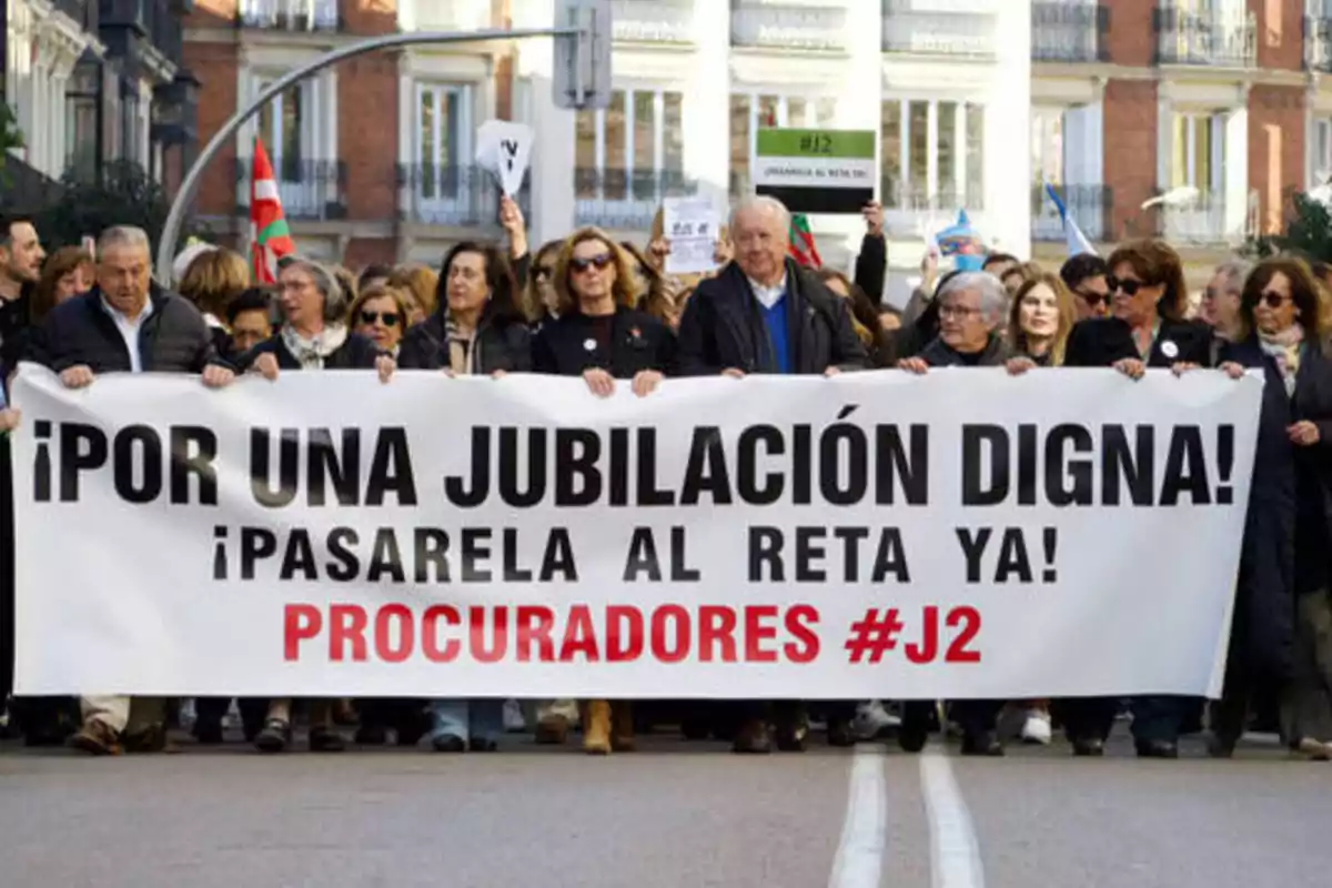 Personas marchando con una pancarta que dice "¡Por una jubilación digna! ¡Pasarela al RETA ya! Procuradores #J2".