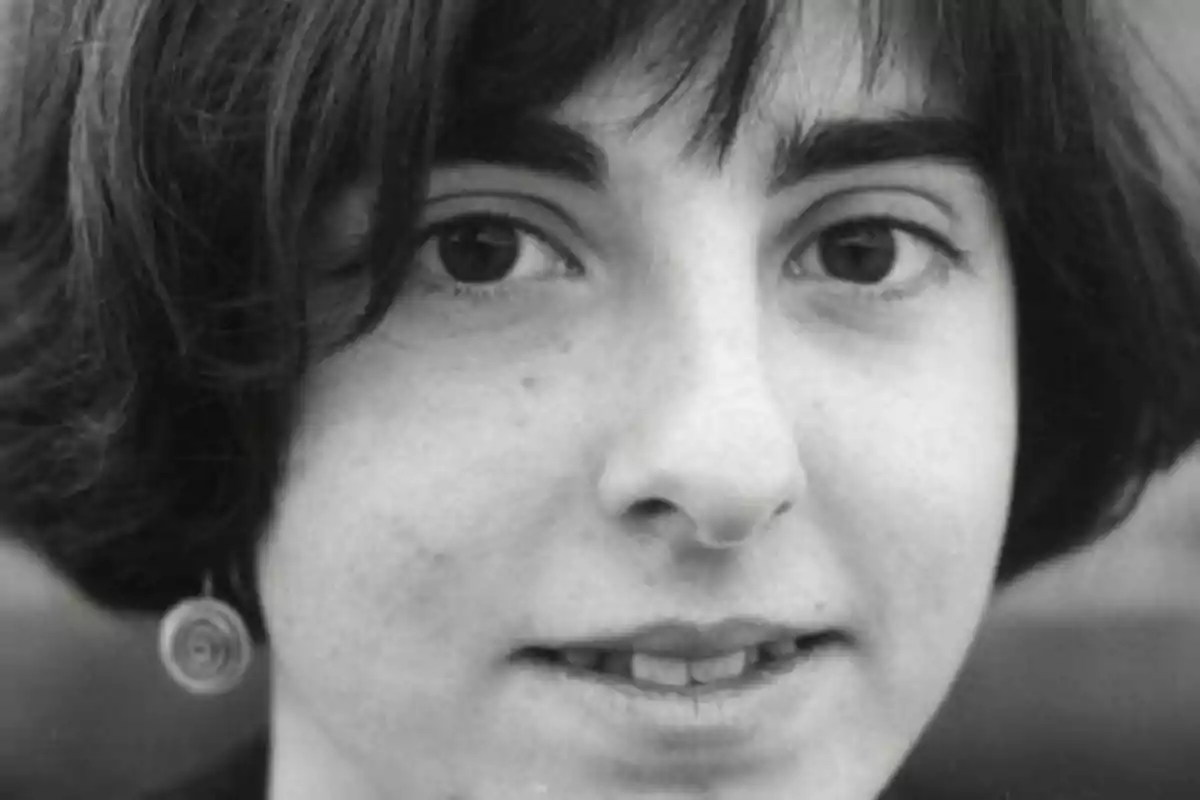 Retrato en blanco y negro de una persona con cabello corto y oscuro, mirando directamente a la cámara.