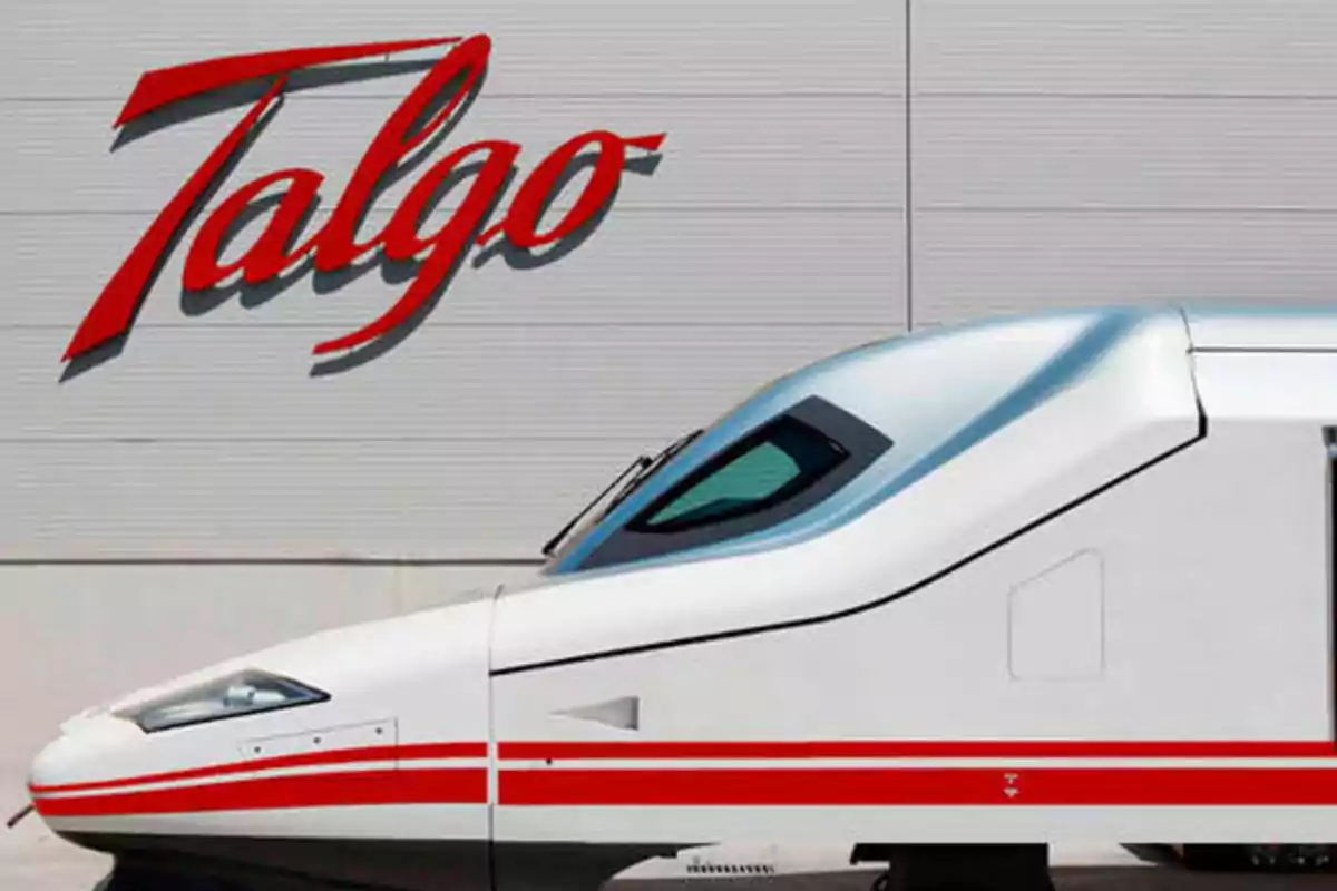 Tren de alta velocidad Talgo frente a un edificio con el logotipo de Talgo.