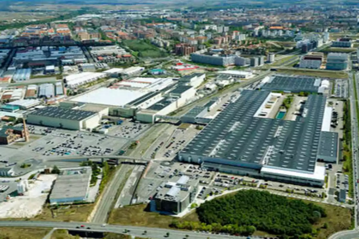 Vista aérea de un parque industrial y una ciudad en el fondo.