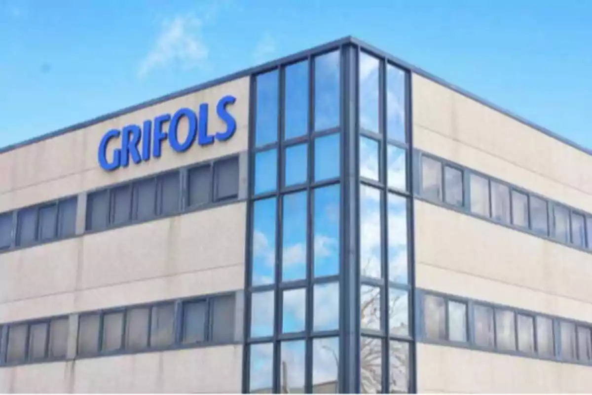 Edificio de oficinas de Grifols con fachada de vidrio y cielo despejado.