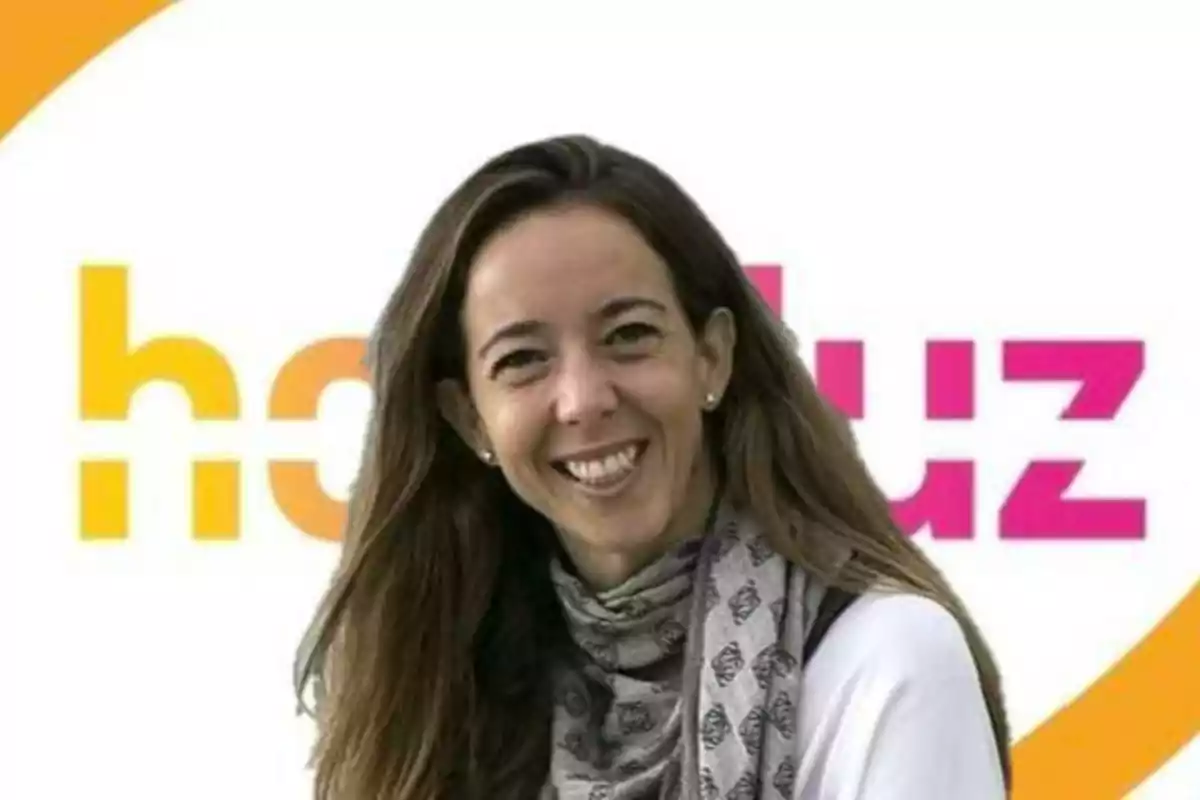 Una mujer sonriente con una bufanda gris frente a un logotipo colorido de Holaluz.