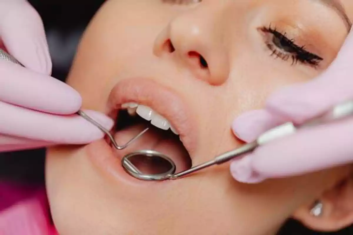 Paciente recibiendo un examen dental con herramientas odontológicas.