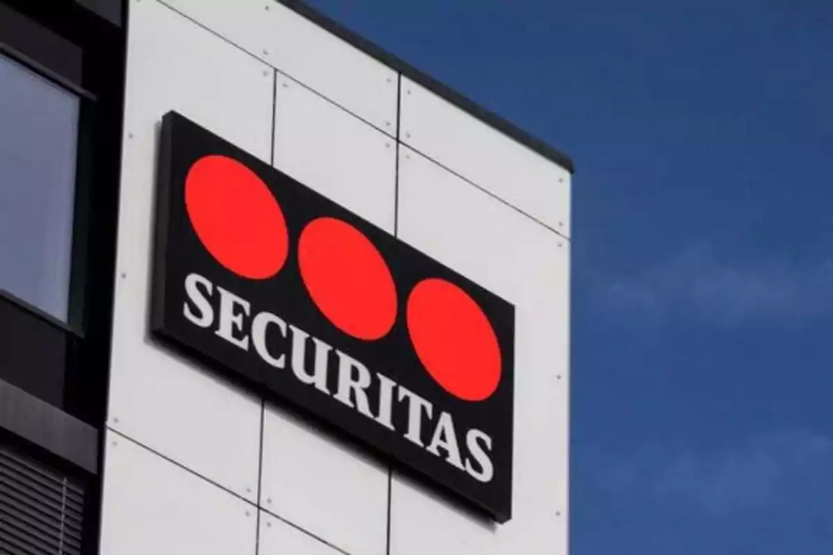 Letrero de Securitas con tres círculos rojos sobre un fondo negro en la fachada de un edificio.