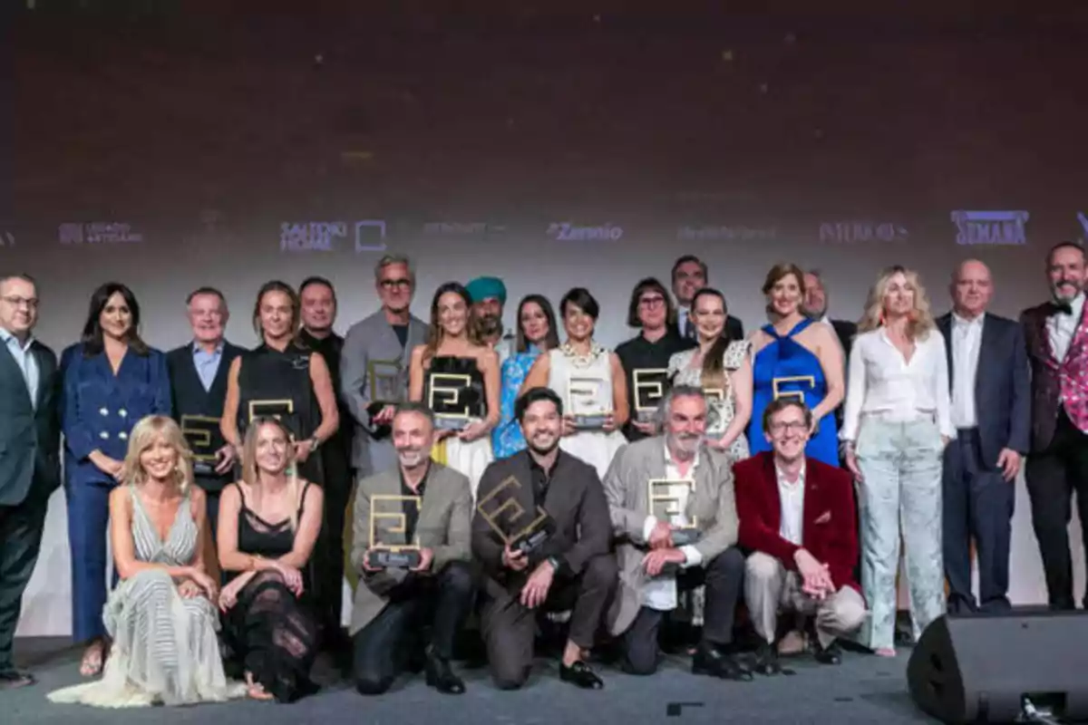 Un grupo de personas posando con trofeos en un evento de premiación.