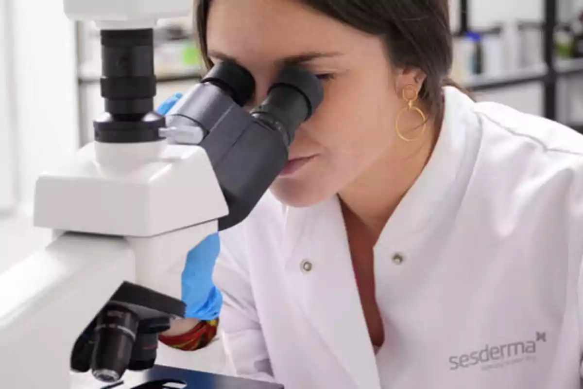 Una científica observando a través de un microscopio en un laboratorio.