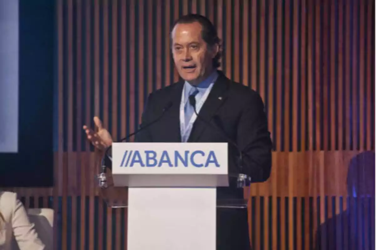 Un hombre hablando en un podio con el logotipo de ABANCA.