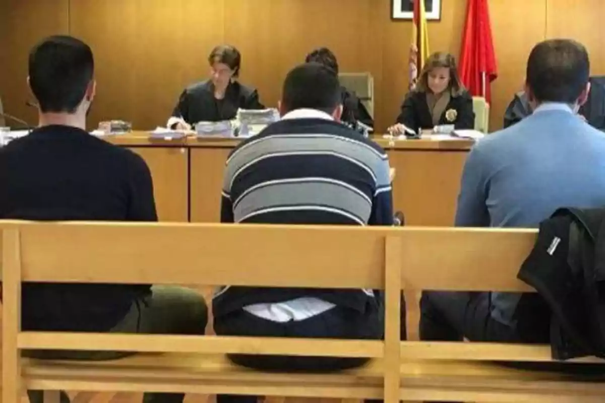 Personas sentadas en una sala de tribunal frente a un panel de jueces.