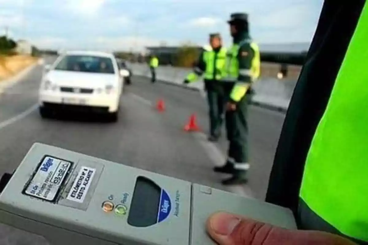Control de carretera con agentes de tráfico y un dispositivo de alcoholemia.