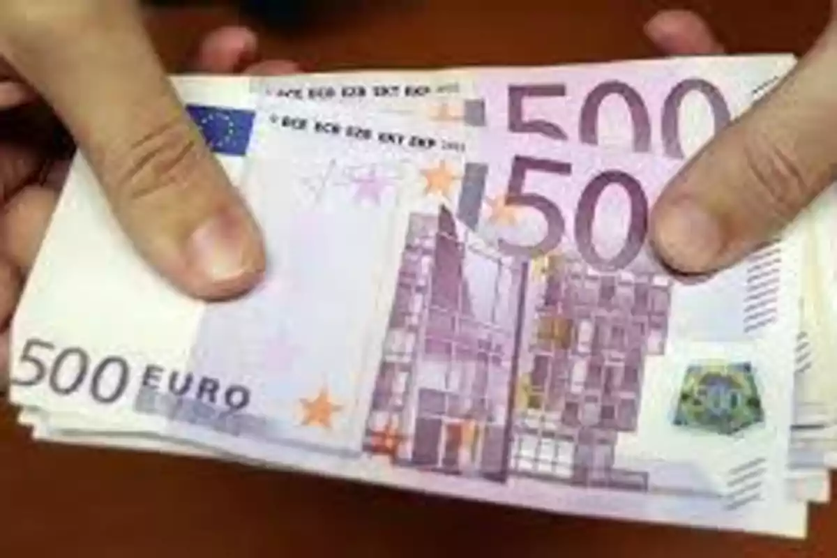 Manos sosteniendo billetes de 500 euros.