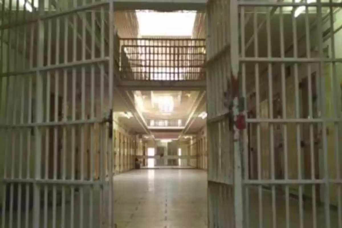 Una prisión con puertas de celdas abiertas y pasillos vacíos.