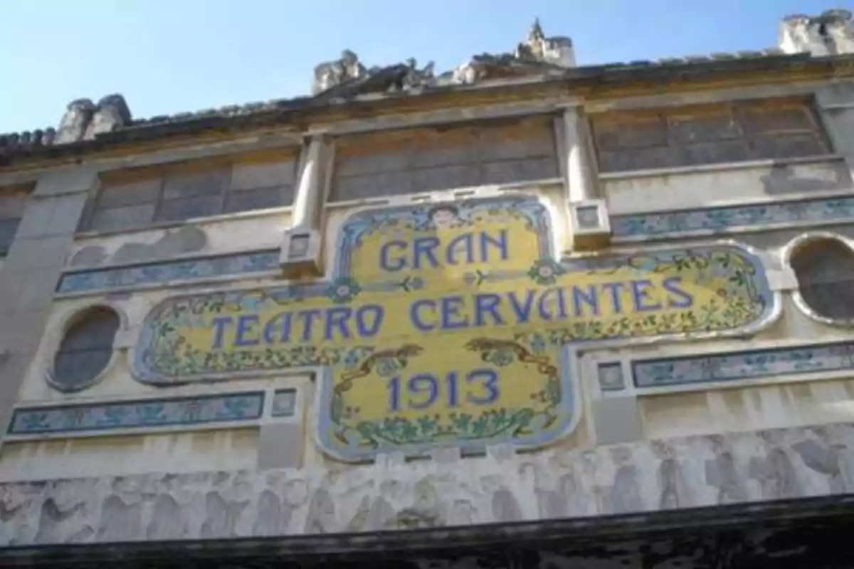 Fachada del Gran Teatro Cervantes con un letrero que indica su inauguración en 1913.