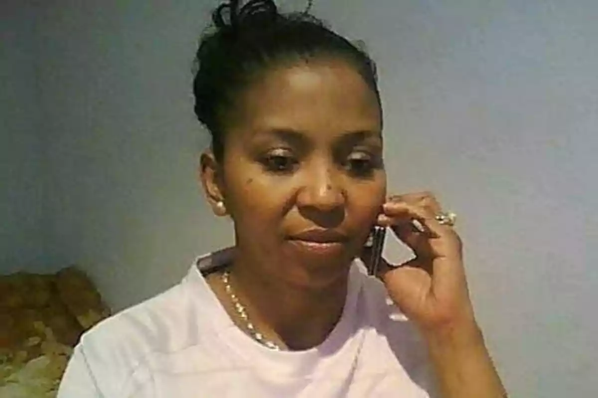 Mujer hablando por teléfono móvil en una habitación.
