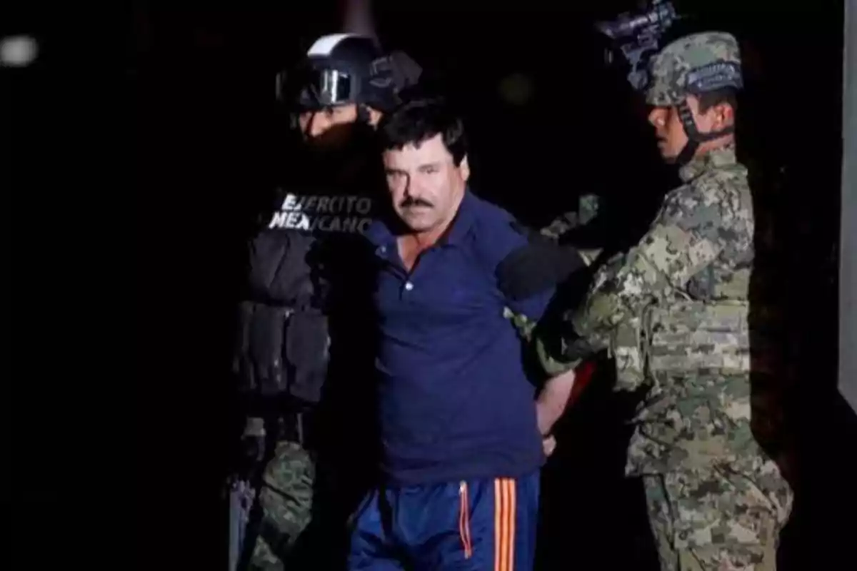Un hombre esposado escoltado por dos soldados del Ejército Mexicano.