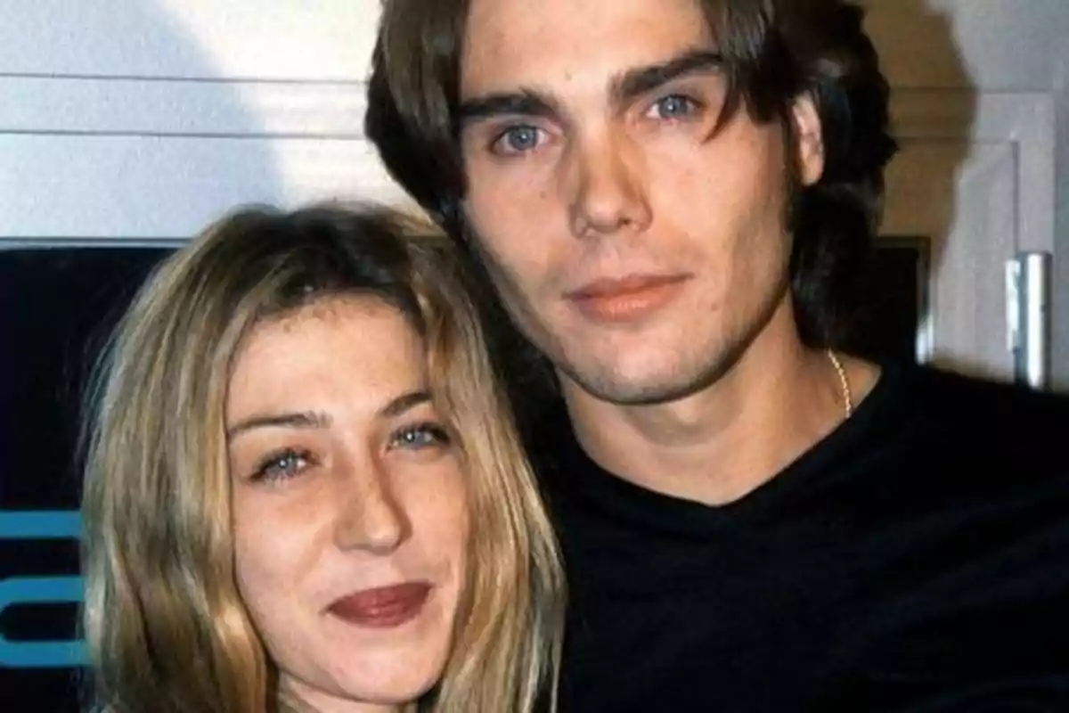 Una pareja joven posando para una foto, ambos con cabello largo y ojos claros.