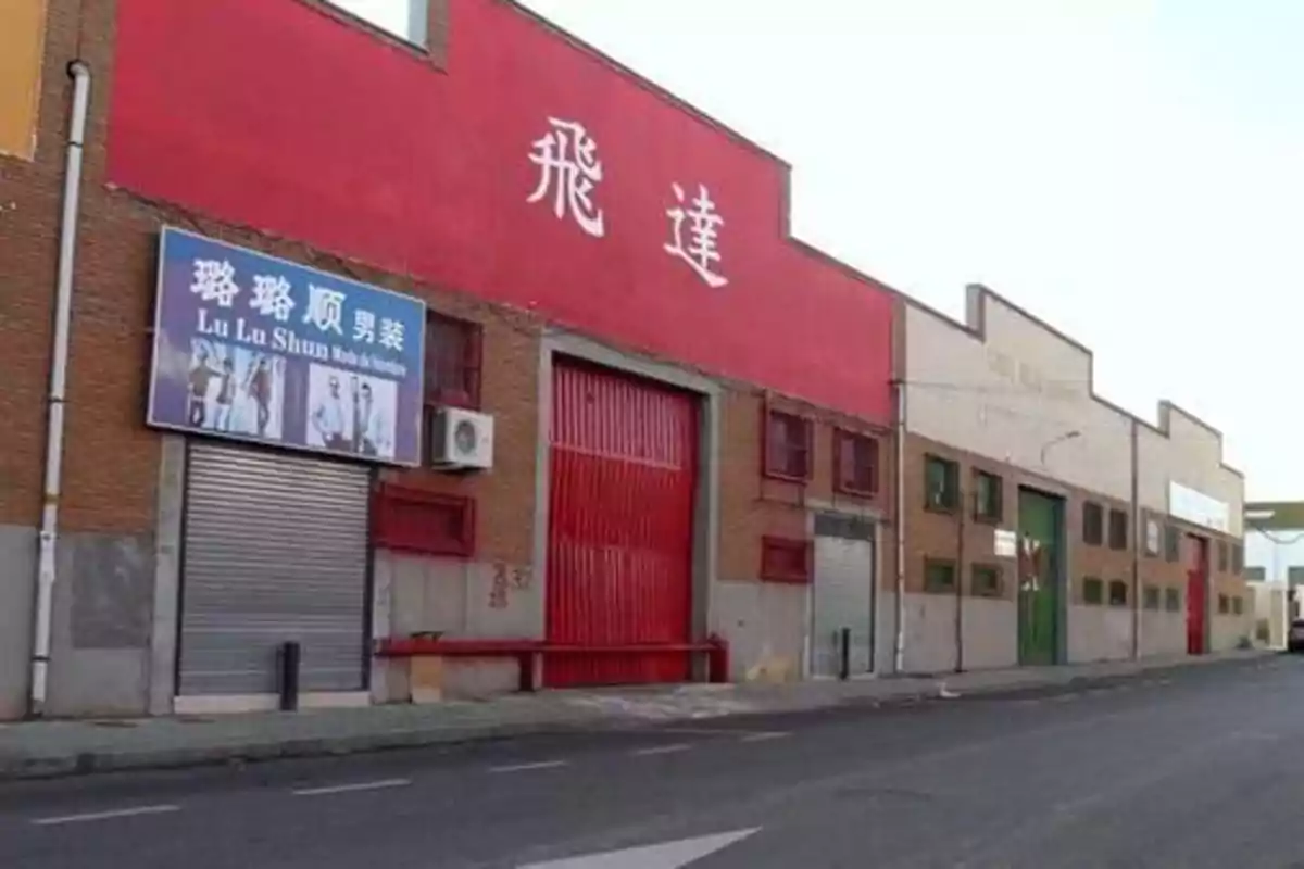 Fachada de un edificio industrial con un cartel en chino y otro cartel que dice "Lu Lu Shun" sobre una tienda de ropa masculina.