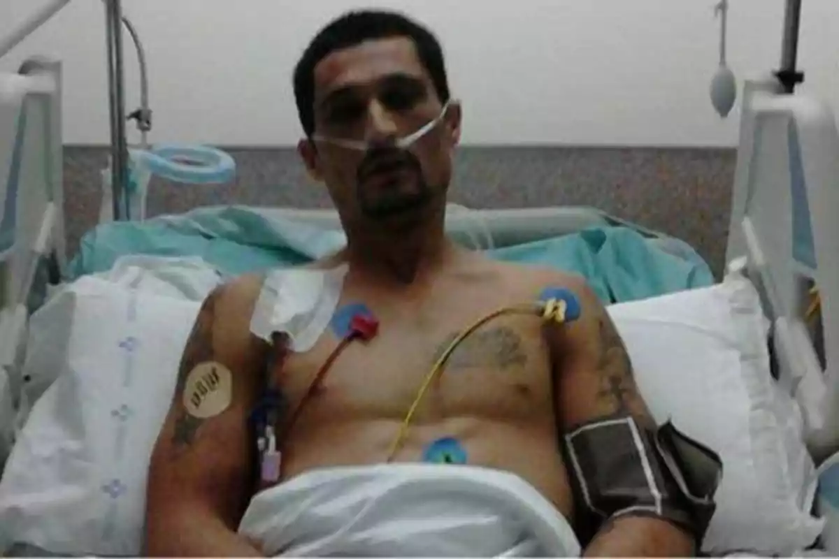 Hombre acostado en una cama de hospital con tubos de oxígeno y electrodos en el pecho.