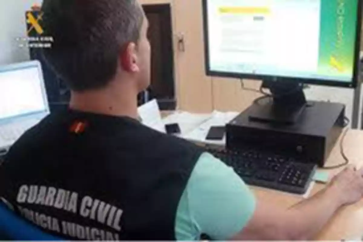 Un agente de la Guardia Civil trabajando en una computadora en una oficina.