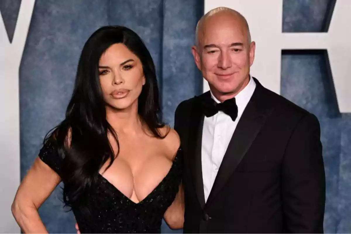 Dos personas posando juntas en un evento formal con fondo azul. Dos personas posando juntas en un evento formal con fondo azul.