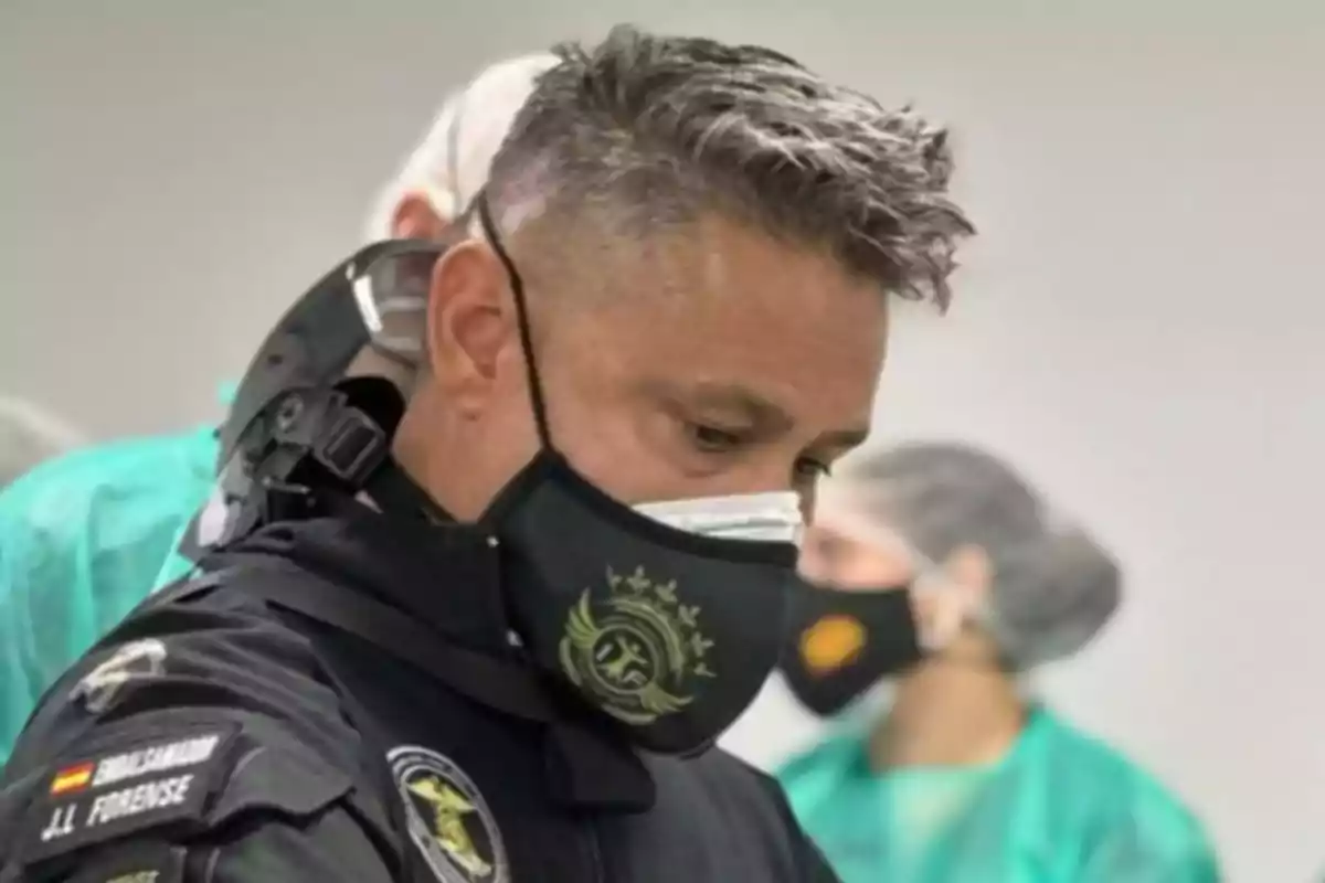 Un hombre con uniforme y mascarilla negra en un entorno médico. Un hombre con uniforme y mascarilla negra en un entorno médico.