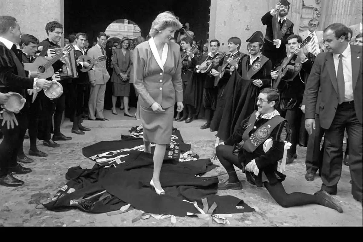 Una mujer camina sobre capas extendidas en el suelo mientras un grupo de músicos la rodea y toca instrumentos.