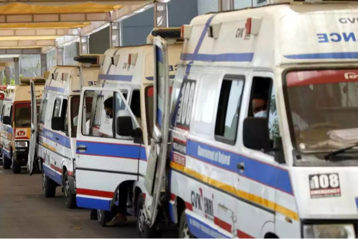 Ambulancias alineadas en una fila bajo un techo.