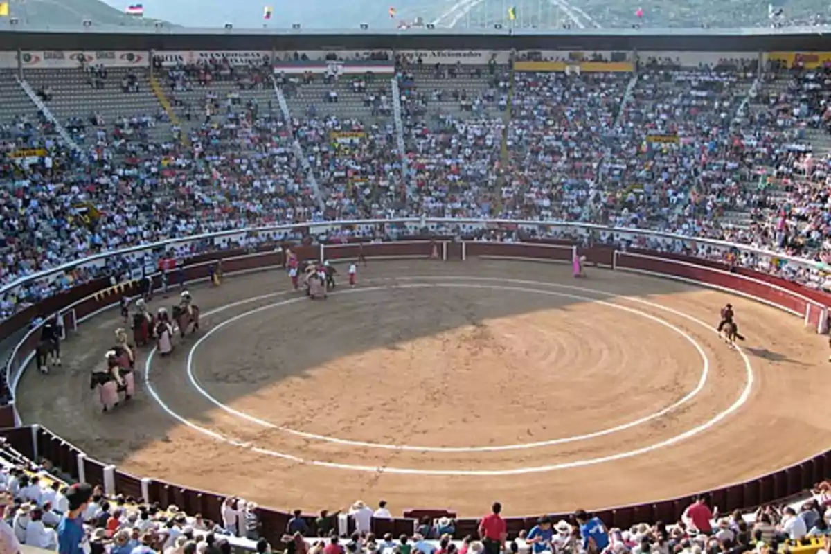 Una plaza de toros llena de espectadores durante un evento taurino. Una plaza de toros llena de espectadores durante un evento taurino.