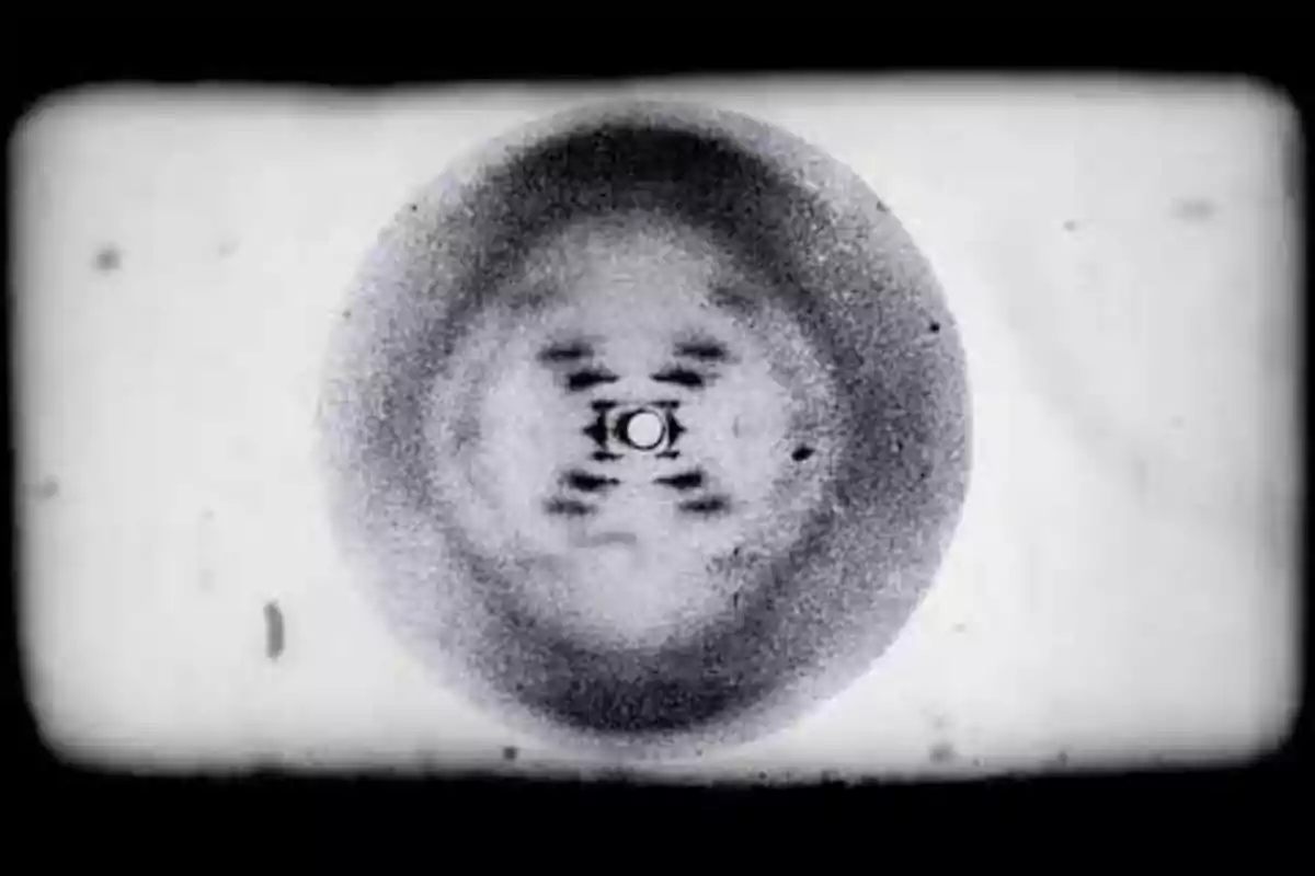 Imagen en blanco y negro de un patrón de difracción circular con un diseño simétrico en el centro. Imagen en blanco y negro de un patrón de difracción circular con un diseño simétrico en el centro.