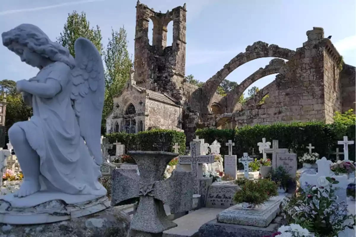 Un cementerio con una estatua de ángel en primer plano y ruinas de una iglesia al fondo.