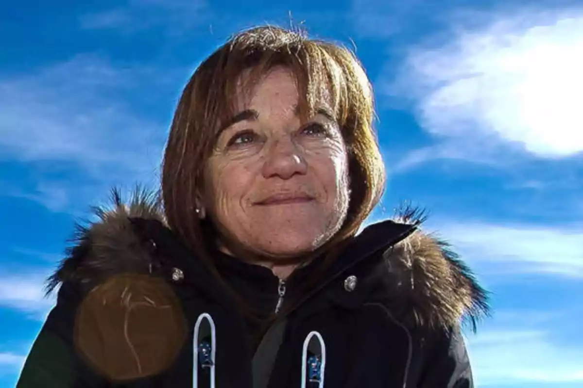 Una mujer con chaqueta de invierno y fondo de cielo azul.