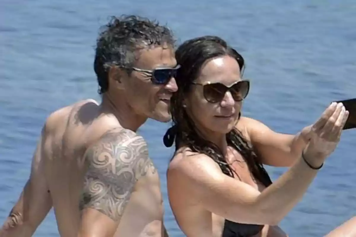 Una pareja en la playa tomando una selfie juntos.