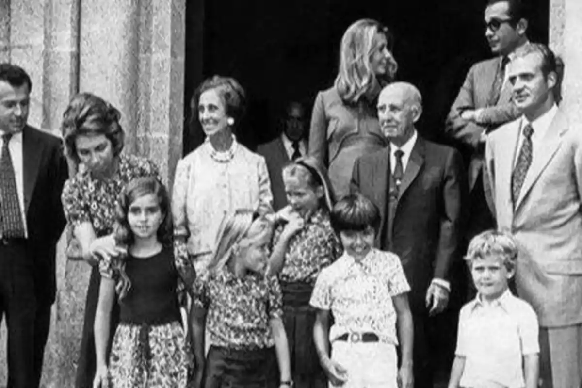 Un grupo de personas, incluyendo adultos y niños, posando frente a un edificio de piedra.