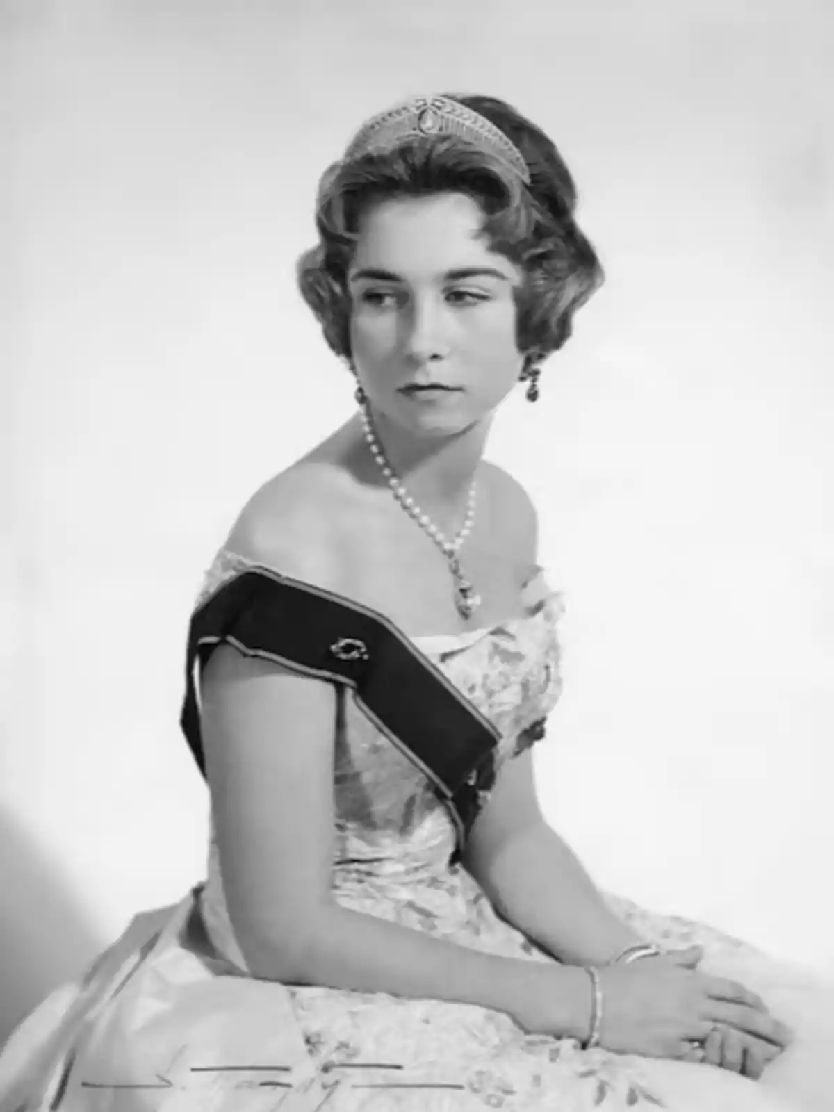 Una mujer joven con un vestido elegante y una tiara, mirando hacia un lado. Una mujer joven con un vestido elegante y una tiara, mirando hacia un lado.