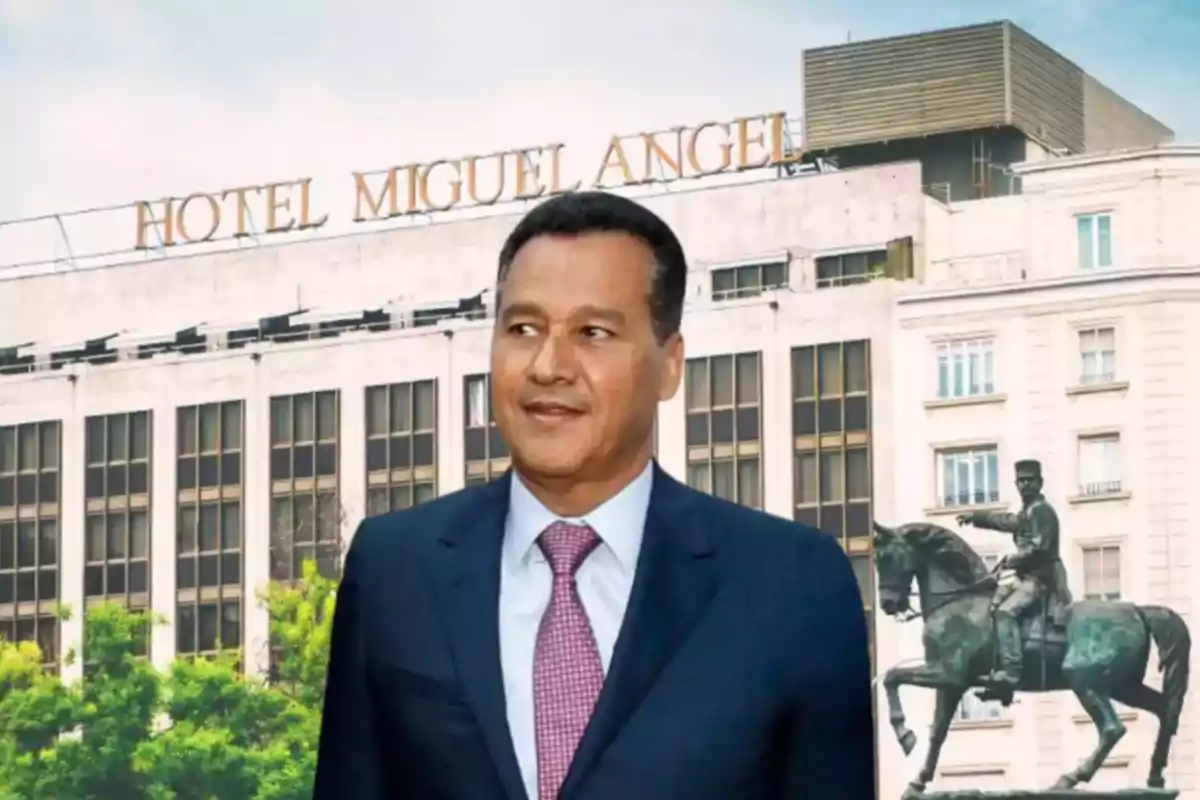 Hombre con traje y corbata de pie frente al Hotel Miguel Ángel con una estatua ecuestre al fondo Hombre con traje y corbata de pie frente al Hotel Miguel Ángel con una estatua ecuestre al fondo